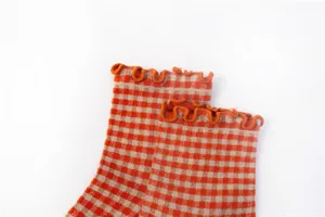 Orange and beige checkered pattern socks with cute ruffled lettuce edge design for women.