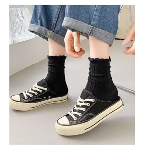 Black ruffle mid-tube socks paired with canvas casual shoes, stylish Japanese daily wear detail.