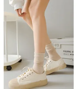 Détail en gros plan de chaussettes mi-mollet en coton uni pour femmes avec chaussures.