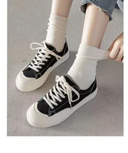 Weiße gerippte Socken kombiniert mit schwarzen Segeltuch-Sneakern für Damen im Frühling