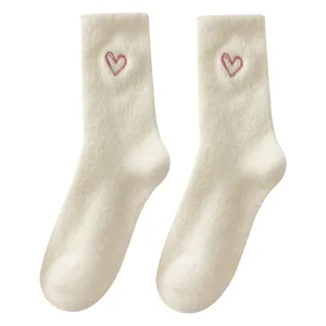 Cozy winter plush mid-tube socks with cute red heart embroidery, soft warm fuzzy fabric for women.