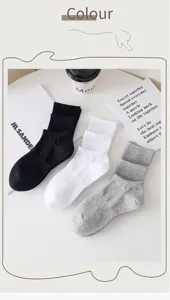 Close-up detail shot of casual solid color mid-calf socks in black, white and grey colors.