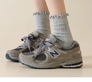 Detailed view of women's grey mid-tube socks featuring delicate lace ruffle and sweet bow embroid.