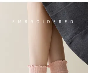 Close-up detail of women's ruffled mid-tube socks with ribbed knit and delicate lace trim.