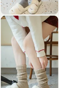 Detail view of knitted footed leg warmers and plush slippers, perfect cozy autumn style.