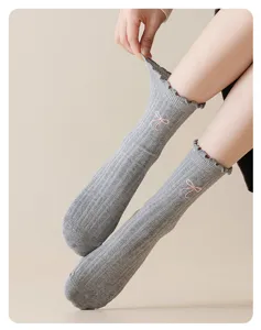 Detail view of grey ribbed cotton mid-calf socks with cute pink embroidered bow design.