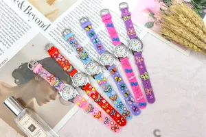 Gros plan détaillé de montres à quartz en silicone coloré pour filles avec breloques papillon.