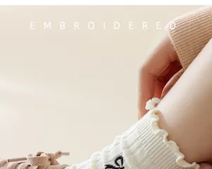 Detailed shot of cute ruffled trim bow embroidered mid-tube socks in sweet style for daily wear.