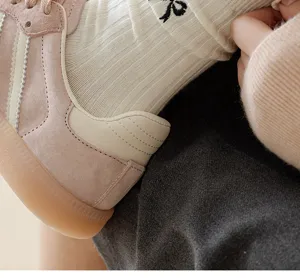 Detailed view of women's cute bow embroidered knit mid-tube socks and retro casual sneakers.