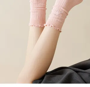 Pink ruffled knit crew socks featuring cute embroidered bow details. Soft and stylish daily wear.