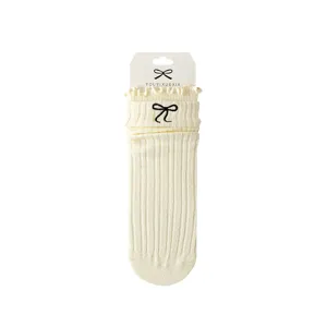 Women ribbed mid-calf socks with black embroidered bow and cute ruffles, cream color.