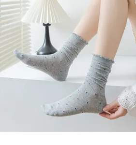 Details of grey ruffled ankle socks with sweet black polka dots, soft breathable knit fabric.