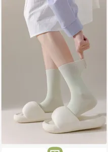 Comfortable women's mid-tube socks paired with thick slides, soft cotton fabric detail shot.