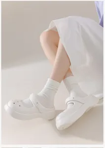 Detail view of comfortable white cotton slouch socks worn with stylish platform shoes.