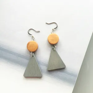 Detail view of geometric wooden earrings with grey triangles and round wood beads