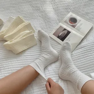 Cozy white wool crew socks for women, warm winter knit stockings with soft and cozy texture.