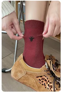 Chaussettes mi-mollet en mélange de laine pour femmes avec broderie abeille noire chic.