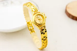 Primer plano detallado de un reloj de cuarzo dorado para mujer con correa fina.