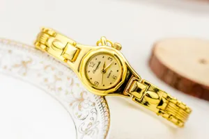 Reloj de cuarzo dorado para mujer con correa de cadena delicada, accesorio elegante.