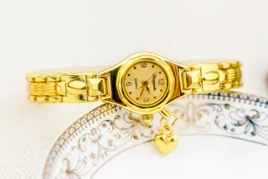 Elegante reloj de pulsera de cuarzo dorado para mujer con bonito colgante de corazón para moda