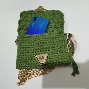 Green handmade crochet phone bag detail showing interior capacity and golden chain strap.