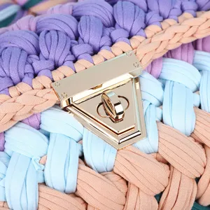 Handmade chunky crochet crossbody bag with stylish gold tone twist lock and colorful fabric yarn.