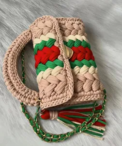 Chic handmade crochet knit handbag featuring colorful stripes, gold chain strap and tassel.