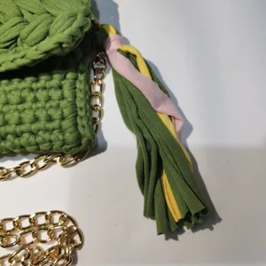 Green handmade crochet phone bag detail, stylish woven crossbody bag with colorful tassel.