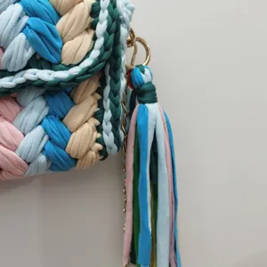 Detailopname van handgemaakte gehaakte handtas, kleurrijk gevlochten garen en kwast.