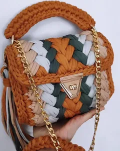 Handmade crochet colorblock shoulder bag detail, featuring gold chain strap and metal lock.