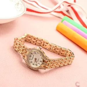 Montre quartz femme de couleur or avec lunette strass et bracelet maillons détail.