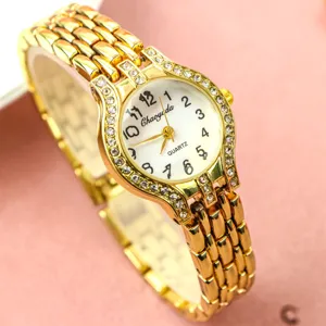 Élégante montre quartz pour femme en or avec strass étincelants, chiffres clairs et bracelet chic.