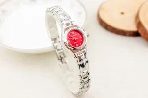 Elegante reloj de cuarzo para mujer con correa de metal plateado y esfera roja brillante.