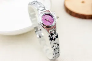 Primer plano de un elegante reloj de cuarzo para mujer con esfera morada y correa de metal.