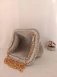 Magnifique sac pochette crocheté main avec des fils dorés et une chaîne élégante.