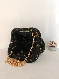 Sac bandoulière tricoté noir et doré fait main avec texture unique et chaîne dorée élégante.