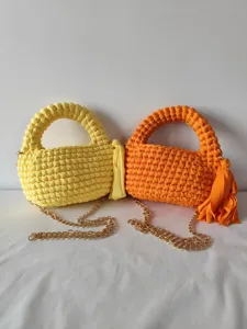 Handmade woven crossbody chain bag detail showing yellow and orange crochet purse with metal strap.