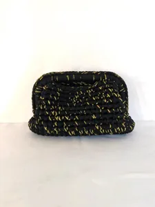 Detaillierte Nahaufnahme der schwarz-goldenen Strick-Clutch mit einzigartiger Webstruktur.