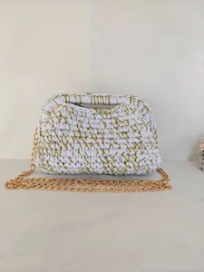 Détail de sac à main crocheté blanc fait main avec fil doré étincelant et chaîne métallique.