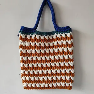 Handgemaakt gehaakt handtas detail, opengewerkte kleurenblok strepen tote bag weergave.