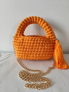 Handmade orange crochet crossbody bag with chunky handle, gold chain strap and stylish tassel detail.