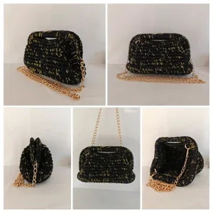 Sac bandoulière noir crocheté main avec fil doré, texture rétro et détail de chaîne.