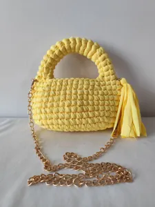 Handmade yellow crochet crossbody bag with a golden chain strap and stylish tassel detail.
