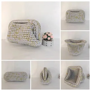 Handgemachte Häkel-Clutch Tasche Details, grau und gold gewebte Textur, Metallrahmen.