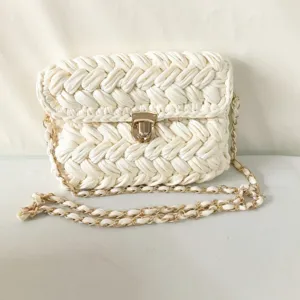 Handmade white crochet crossbody bag detail showing chunky knit texture and gold lock clasp.