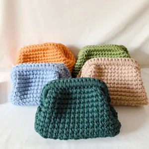 Closeup details of handmade chunky crochet clutch bags showing soft textured knit design in multi.