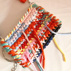 Colorful dopamine crochet shoulder bag with vibrant woven fabric strips and stylish metal chain strap.