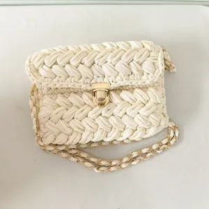 Handmade crochet woven crossbody bag for women with gold chain strap and metal clasp closure.