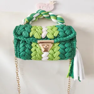 Handmade green crochet handbag with chunky knit handle, gold chain strap, and chic tassel.
