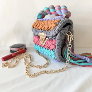 Handmade colorful crochet crossbody bag with gold chain strap and stylish multi-color design.